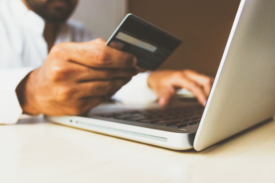 Payment Options person holding credit card in front of laptop