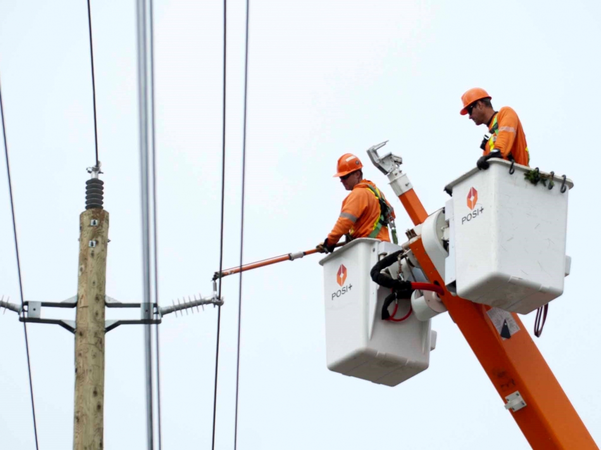 Two men in a bucket working on a electrical line